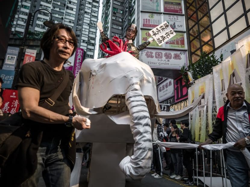 Demonstrators parade a white elephant made of cardboard symbolising buildings and government projects claimed to be wasting public money. Photo: AFP