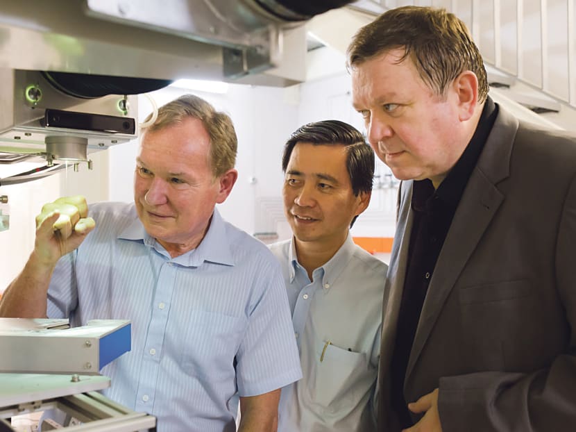 (From left) NTU professors David Payne, Tjin Swee Chuan and Nikolay Zheludev examining a newly-drawn optical fibre cable. Photo: NTU
