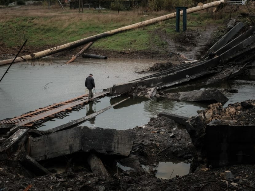 A man crosses the destroyed bridge with water bottles in the frontline town of Bakhmut in the Donetsk region on Oct 11, 2022, amid the Russian invasion of Ukraine. A man crosses the destroyed bridge with water bottles in the frontline town of Bakhmut in the Donetsk region on Oct 11, 2022, amid the Russian invasion of Ukraine.
