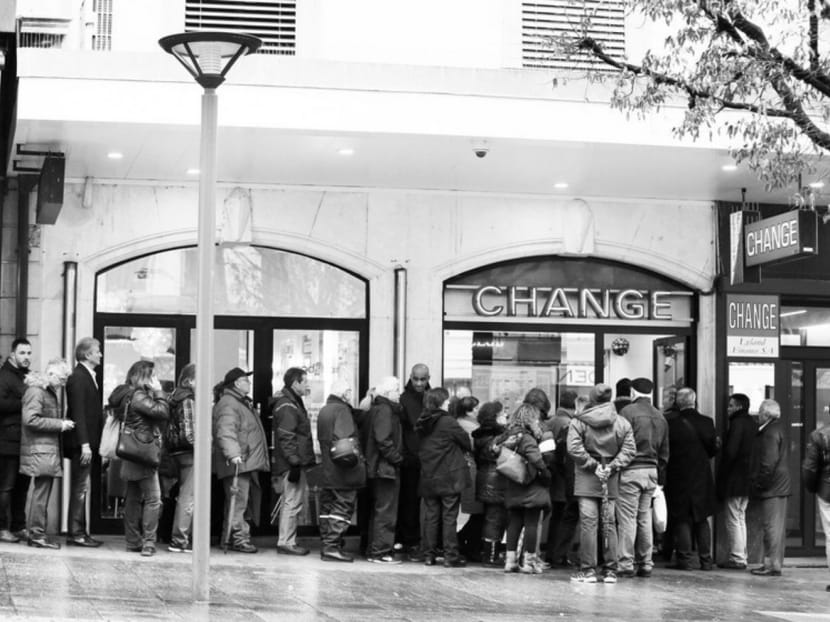 People queueing outside a currency exchange office in Geneva last month. The Swiss National Bank’s surprise decision to remove a ceiling on the Swiss franc on Jan 15 thrust the sharpest dagger into QE’s heart. Photo: Reuters