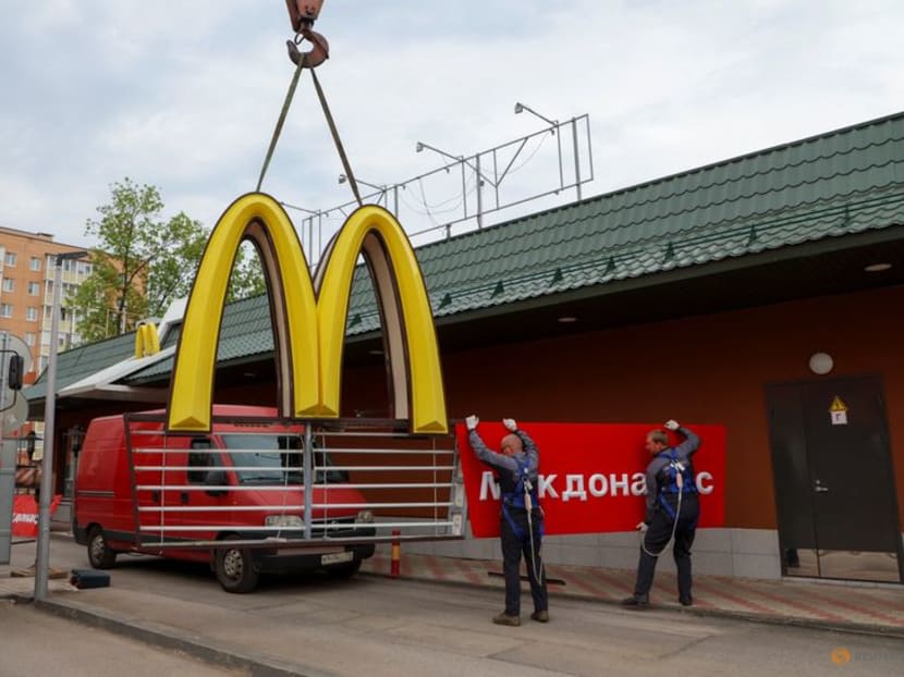 Workers use a crane to dismantle the McDonald's Golden Arches while removing the logo signage from a drive-through restaurant of McDonald's in the town of Kingisepp in the Leningrad region, Russia June 8, 2022.