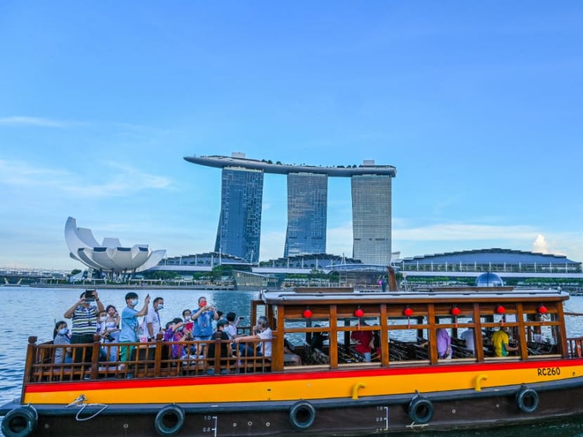 In this photograph taken on Feb 18, 2022, people take a boat tour before the Marina Bay Sands hotel and resort in Singapore.