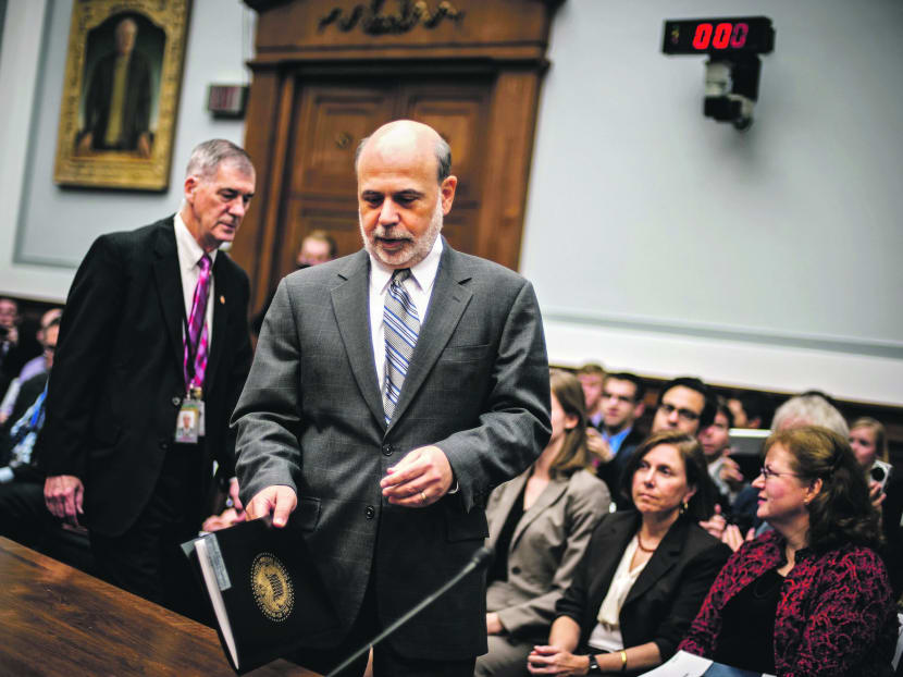Mr Bernanke (right) before delivering his report in Washington yesterday. Photo: Reuters