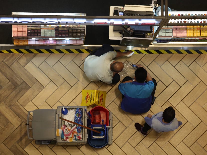 A cleaner cleans the area where a 35-year-old man died after falling several storeys inside Ngee Ann City mall on July 14, 2019.