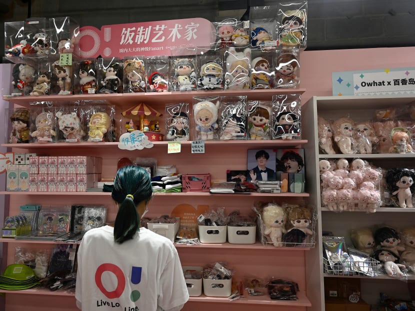 A salesperson checks dolls and celebrity idol-related products at a fan merchandise store at a shopping mall in Beijing on Sept 2, 2021. Authorities say the new rules are needed to curb excessive aspects of fan culture, including cyberbullying, stalking, doxxing and bitter online wars between fandoms.