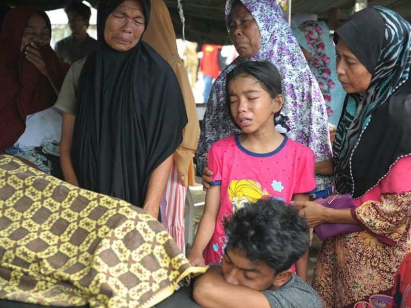 An Acehnese family grieving for their relative who died after a powerful earthquake in Pidie Jaya, Aceh province yesterday.  The rescue effort involved thousands of search officials, villagers, soldiers and police, who are concentrating on Meureudu, a severely affected town near the epicentre. PHOTO: AFP