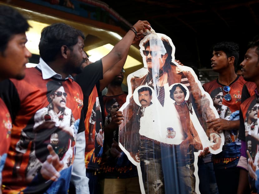 Fans pouring milk on a cutout of actor Rajinikanth. Idol worship has led to milk shortages whenever Rajinikanth releases a new film. Photo: Reuters