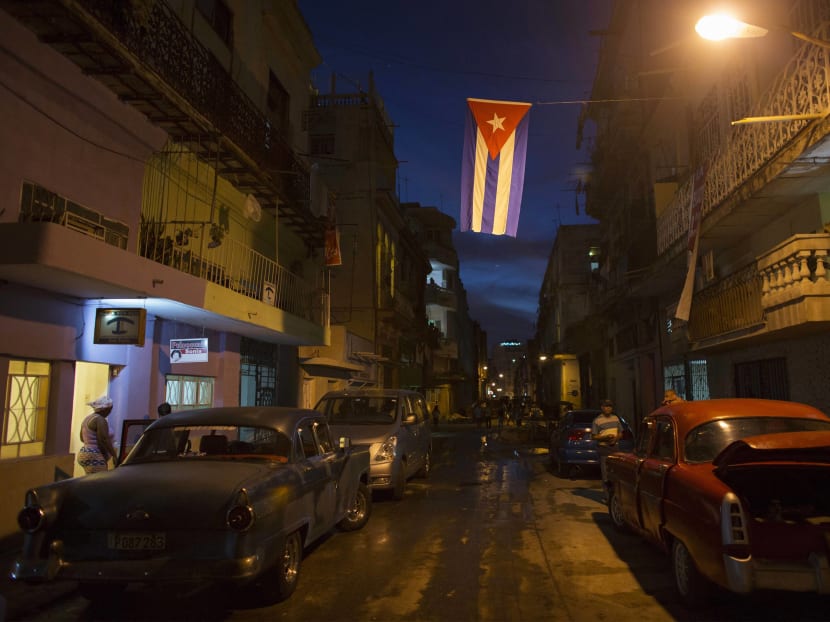 A Cuban national flag hangs over the street in downtown Havana. Photo: Reuters