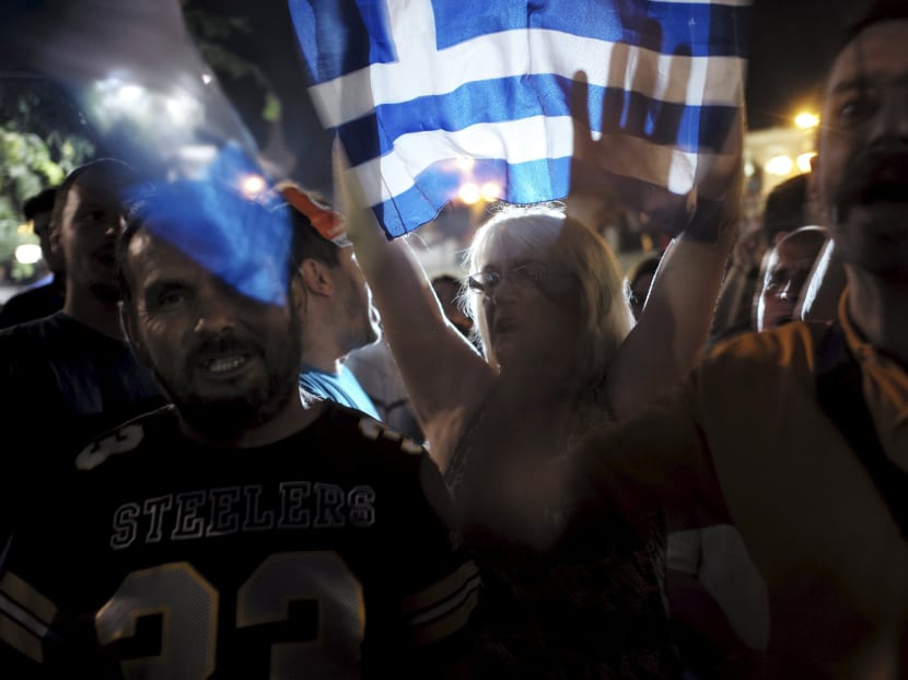 "No" supporters shout slogans and wave Greek national flags during celebrations after a referendum in Athens, Greece July 5, 2015. Photo: Reuters