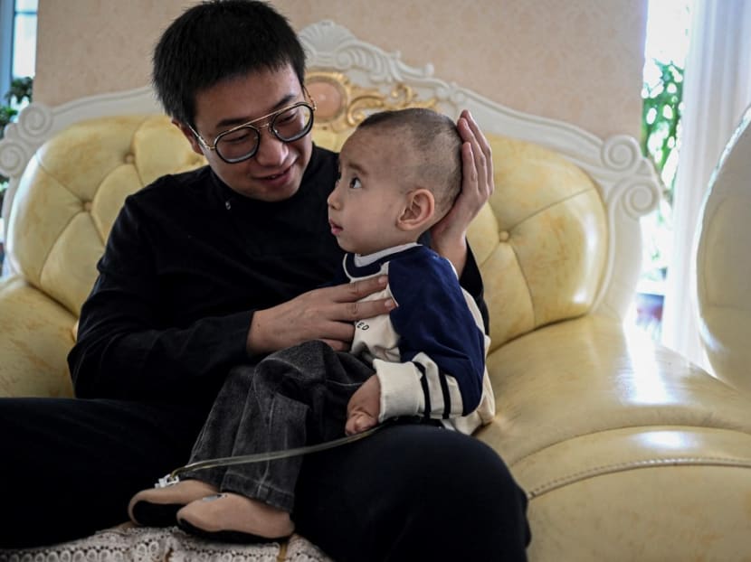 This photo taken on Oct 20, 2021 shows Mr Xu Wei playing with his son Xu Haoyang, who was diagnosed with Menkes syndrome, at home in Kunming in southwestern China's Yunnan province.