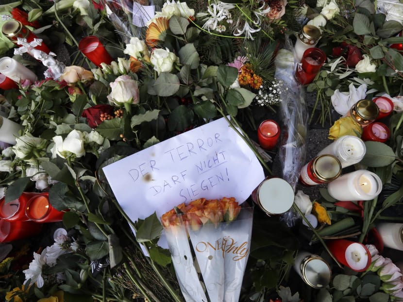 A written sign saying "terror must not win" sits between candles and flowers in Berlin, two days after a truck ran into a crowded Christmas market and killed several people. Photo: AP