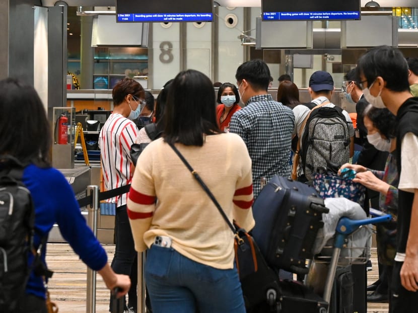 Travellers checking in for a flight at the Singapore Airlines counter in the departure hall of Changi Airport on Dec 2, 2021. Travellers checking in for a flight at the Singapore Airlines counter in the departure hall of Changi Airport on Dec 2, 2021.