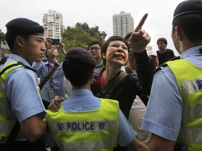 A local villager (centre) gestures at protesters demonstrating against the mainland Chinese shoppers at a suburban district of Yuen Long in Hong Kong. Photo: AP