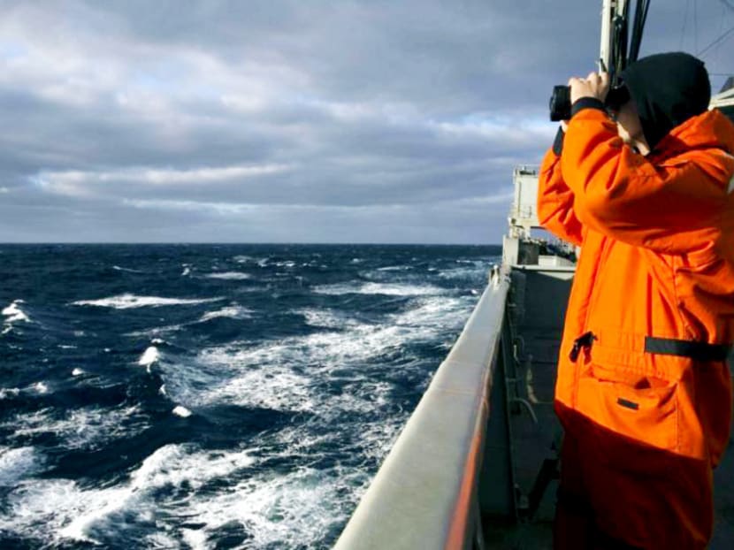 A crew member scans the horizon from Australian Navy ship HMAS Success, which is looking for Flight MH370 in the southern Indian Ocean. Photo: Reuters