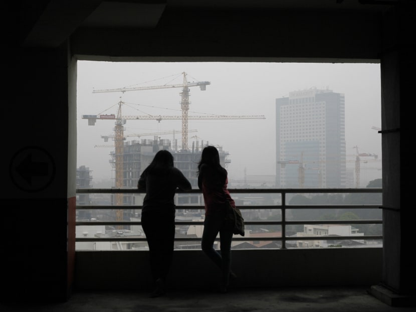 Indonesian women are silhouetted against the city skyline which is shrouded by the haze from forest fires, in Medan, North Sumatra, Indonesia. Photo: AP