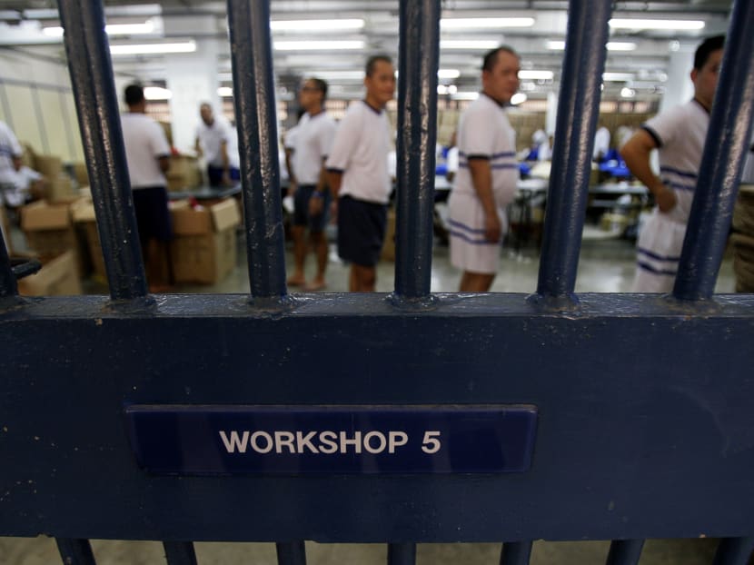 Inmates are seen behind the bars on a gate to a workshop at Singapore's Tanah Merah Prison. Photo: Reuters