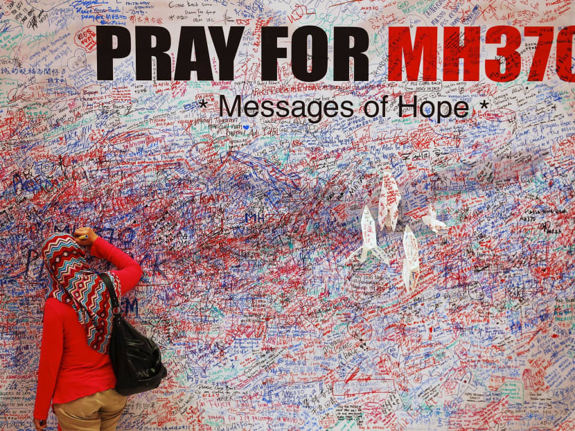 A woman leaves a message of support and hope for the passengers of the missing Malaysia Airlines MH370 in central Kuala Lumpur, on March 16, 2014. Photo: Reuters