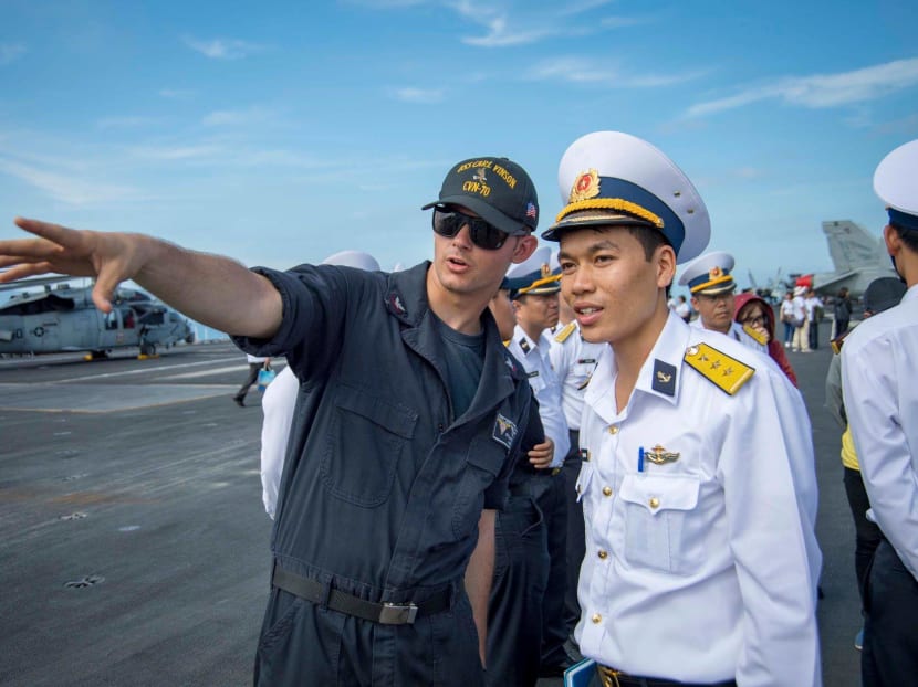 A USS Carl Vinson crew member with a Vietnamese serviceman onboard the American aircraft carrier during its visit to Danang in March.