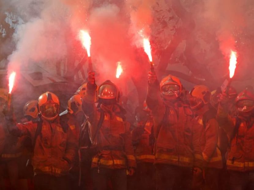 Photo of the day: Firemen raise up flares during a protest against cuts and working conditions in front of Catalonia Parliament in Barcelona, Spain.
