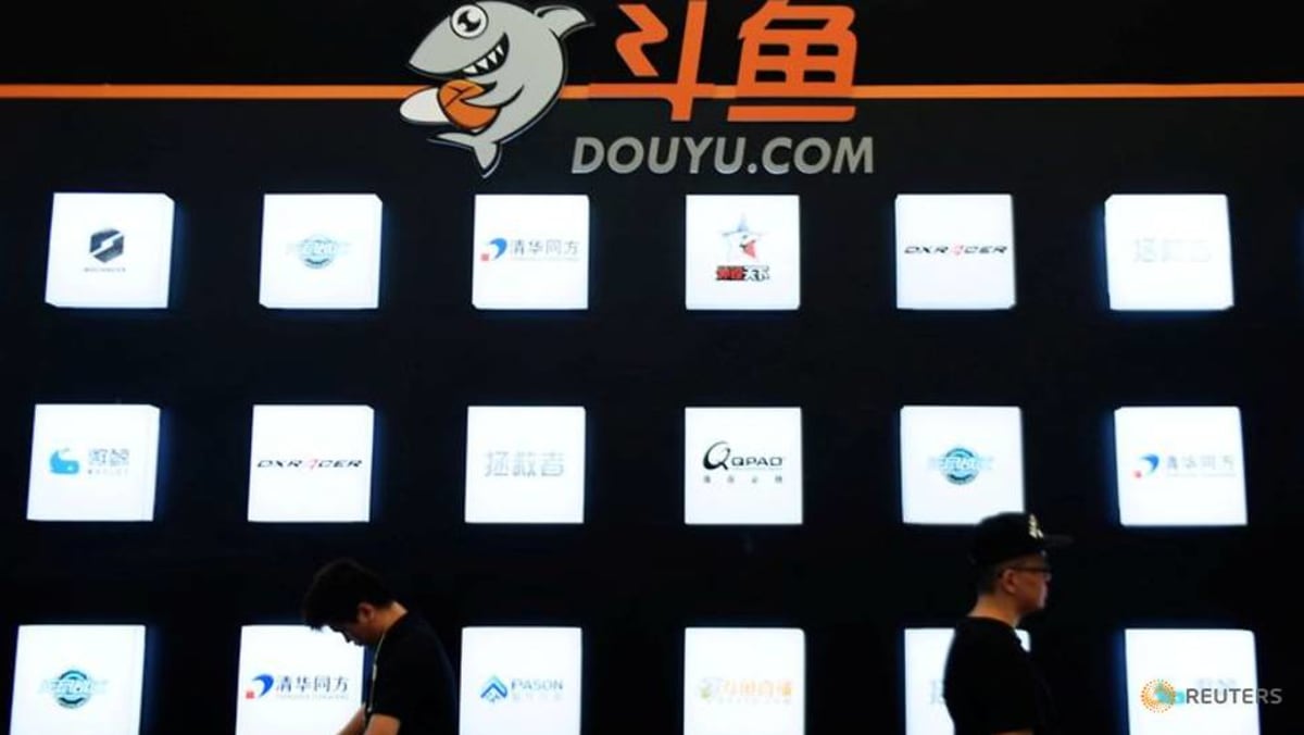 people walk past a booth of live streaming platform douyu at the chinajoy digital entertainment expo in shanghai 1