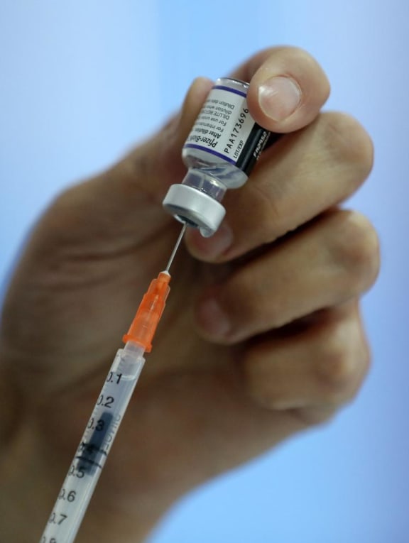 A health worker preparing a dose of the Pfizer-BioNTech vaccine. A health worker preparing a dose of the Pfizer-BioNTech vaccine.