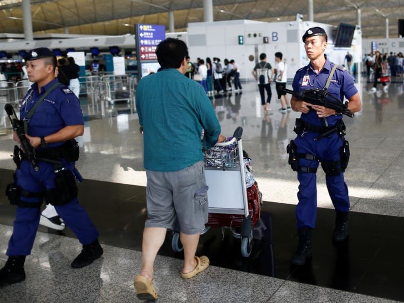 Armed police patrol the departure hall of the airport in Hong Kong after clashes with protesters on Aug 13, 2019. Students from three major universities in Singapore received notice that exchange programmes to Hong Kong have been cancelled.