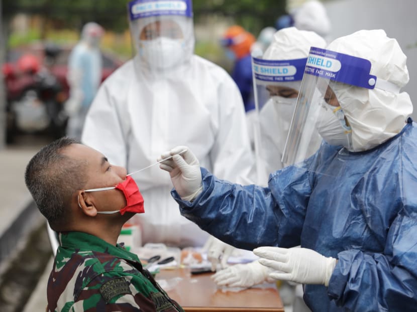 A health worker performs a Covid-19 nose swab test on a man in Bandung, West Java, Indonesia, on May 20, 2020. A health worker performs a Covid-19 nose swab test on a man in Bandung, West Java, Indonesia, on May 20, 2020.