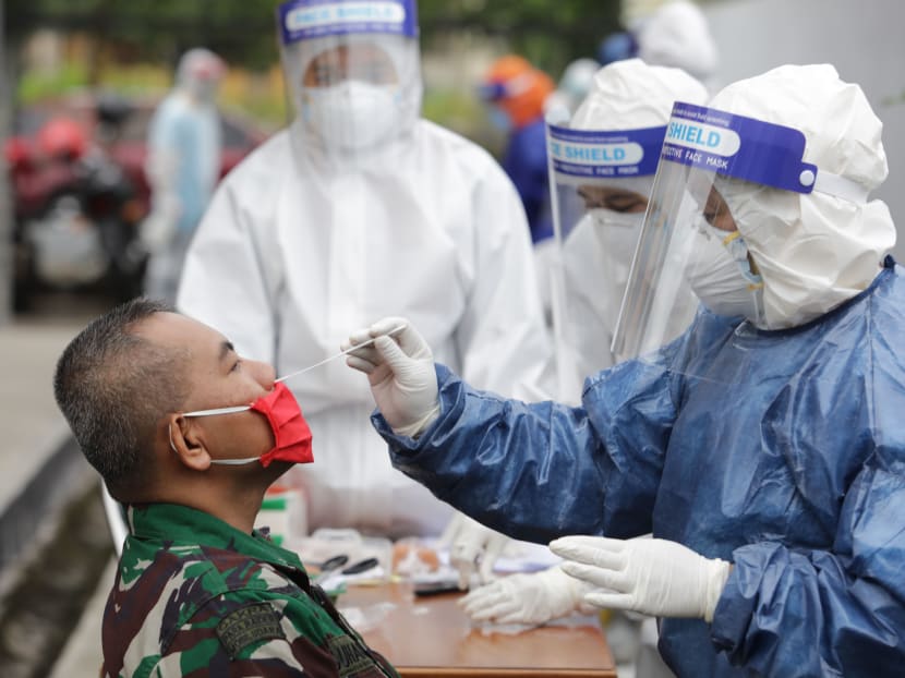 A health worker performs a Covid-19 nose swab test on a man in Bandung, West Java, Indonesia, on May 20, 2020.