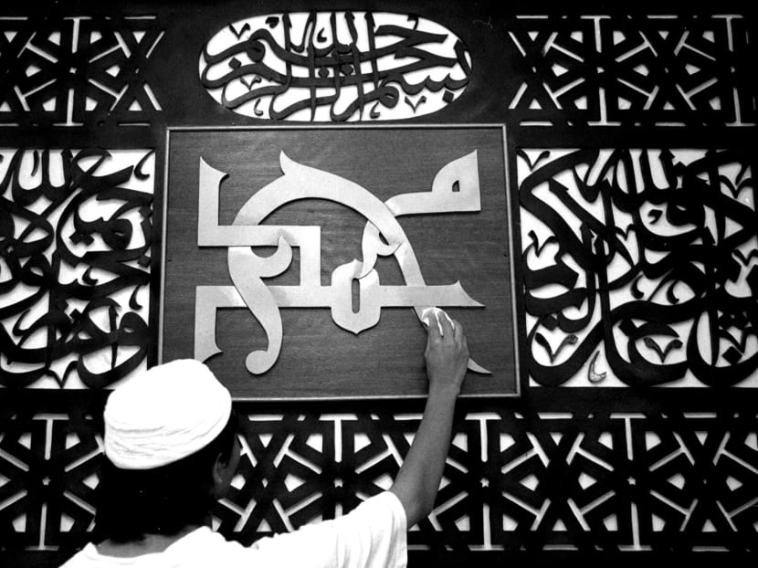 A worker cleans an Islamic plaque of calligraphy saying "Mohammad" on the morning of Eid al-Fitr in a mosque in Kota Bharu, in Malaysia's northeastern state of Kelantan in this January 8, 2000 file photo. Photo: Reuters