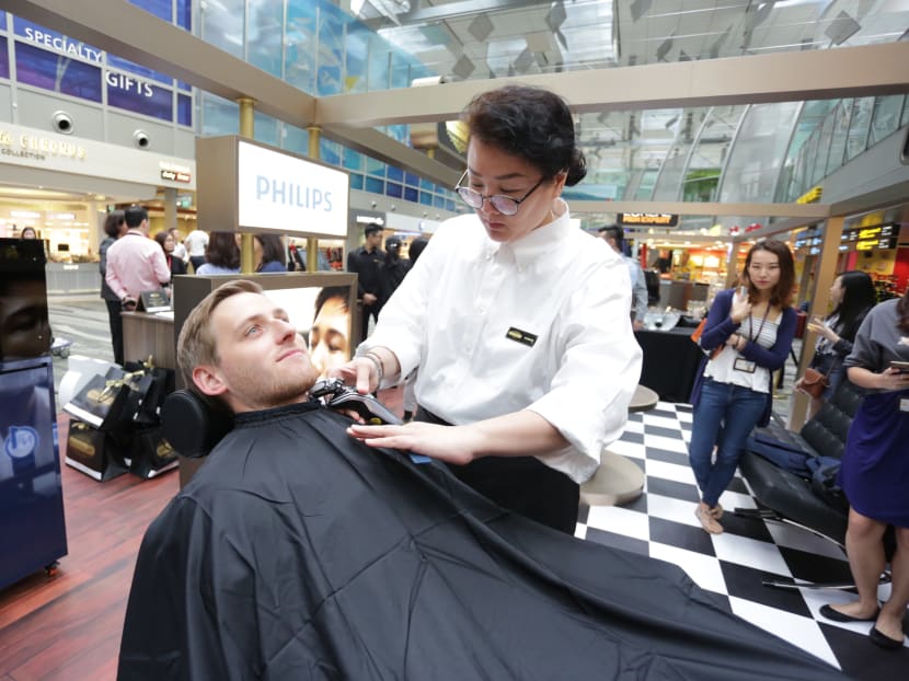 A traveller gets groomed at the Male Grooming Club pop-up barbershop at Changi Airport's Terminal 3 Transit Area. Photo: Royal Philips and L’Oreal Groupe