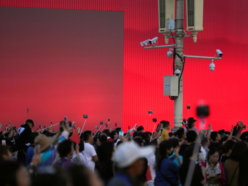 Security cameras in Tiananmen square in Beijing watch over people taking pictures in Sept 2019.