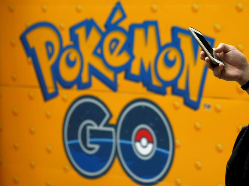 A man uses a mobile phone in front of an advertisement board bearing the image of Pokemon Go at an electronic shop in Tokyo, Japan, July 27. Photo: Reuters