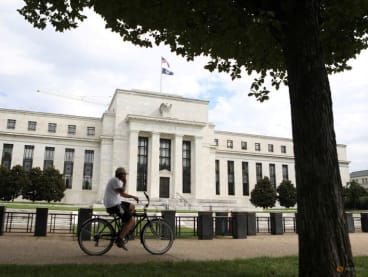 A cyclist passes the Federal Reserve building in Washington, DC, US, on Aug 22, 2018.
