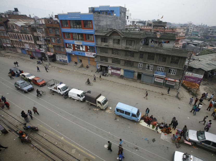 Nepalese rest on a  road beside a line of parked vehicles, a day after a massive earthquake devastated the region and destroyed homes and infrastructure, in Kathmandu, Nepal. Photo: AP