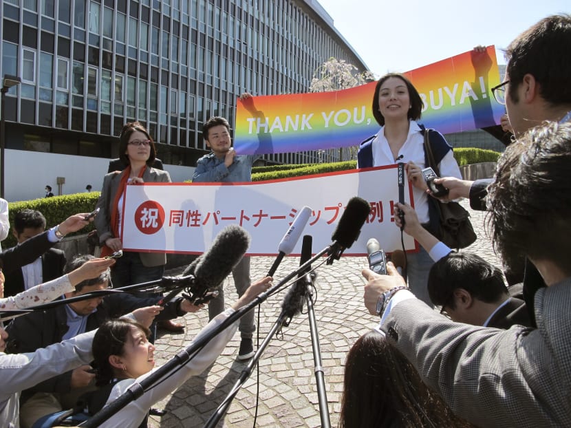 Ms Koyuki Higashi, right, and her partner, Ms Hiroko Masuhara, left, holding a banner reading: "Congratulations: the same sex partnership ordinance" speak to the media in front of Shibuya ward office in Tokyo. Photo: AP