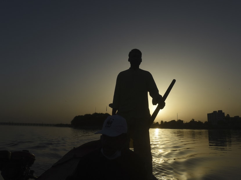 A man rows a boat as he monitors Indus river dolphins along the river near Pakistan's southern Sindh province city of Sukkur, Pakistan on March 23, 2021.