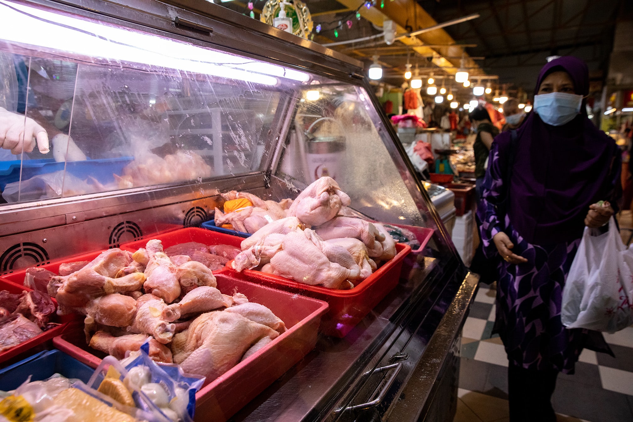 A woman walking past a poultry stall at a wet market in Yew Tee on May 25, 2022.