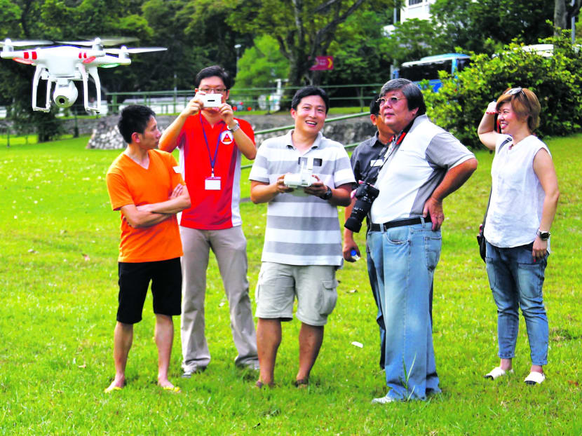 Some photography enthusiasts gathered at the open field outside Outram Park MRT Station yesterday to experience aerial photography using drones where cameras are mounted onto the them. The event marks the 10th year anniversary of the Tanjong Pagar CC Photographic Club. 
PHOTO: ERNEST CHUA