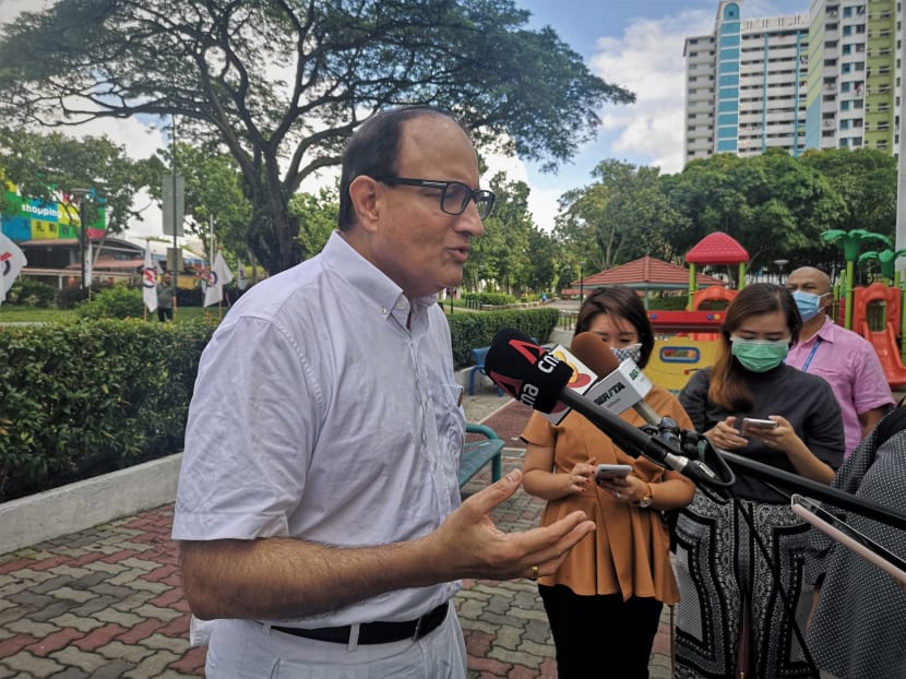 Mr S Iswaran (left) who is leading the People's Action Party team at West Coast GRC, speaking to reporters during a walkabout at Boon Lay Place Market and Food Village on July 4, 2020.