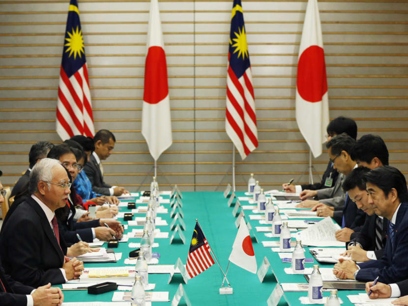 Mr Najib Razak (second from left) in talks with Mr Shinzo Abe (right) in Tokyo yesterday. The Malaysian PM said they spent a lot of time discussing if the Singapore-Kuala Lumpur high-speed rail link project would use shinkansen bullet-train technology. Photo: Reuters