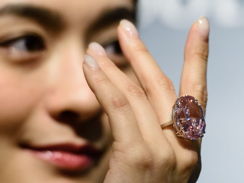 A model posing with a 59.60-carat oval mixed-cut pink diamond during a Sotheby's media preview in Hong Kong on March 29, 2017. Photo: AFP