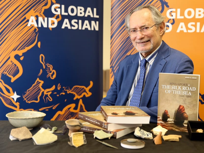 Prof John N. Miksic, the inaugural winner of the NUS Singapore History Prize, posing with his book "Singapore & The Silk Road of the Sea, 1300 - 1800". Photo: Koh Mui Fong/TODAY