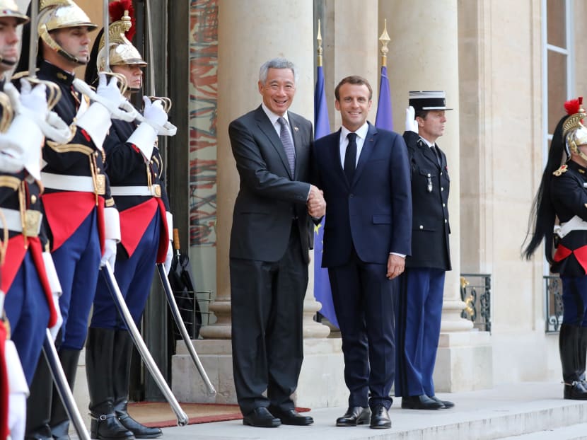 French President Emmanuel Macron welcomes Prime Minister Lee Hsien Loong as he arrives at the Elysee Palace in Paris on Friday, July 13.
