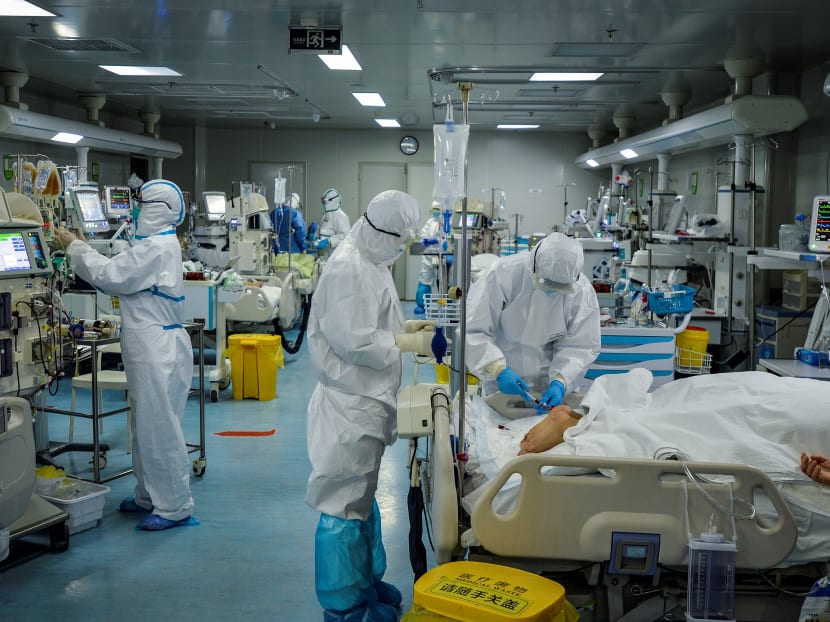 Medical staff treat patients infected by the Covid-19 coronavirus at a hospital in Wuhan in China's central Hubei province. Medical staff treat patients infected by the Covid-19 coronavirus at a hospital in Wuhan in China's central Hubei province.