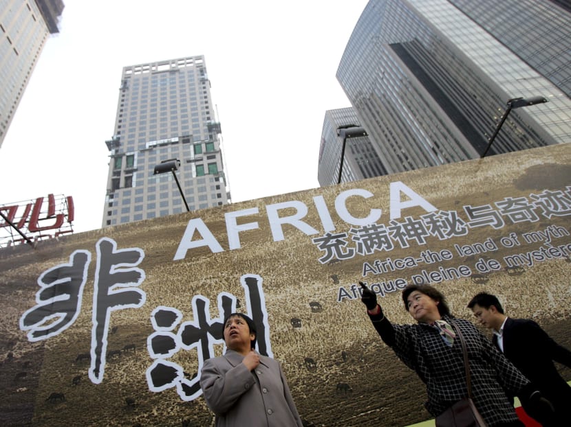 Chinese women stand in front of a billboard which promotes the upcoming China-Africa summit meeting, outside a hotel in Beijing.  China has become a top global source of development financing, giving or lending almost as much as the United States, but its spending produces far less economic growth for recipients, a multinational group of researchers reported. AP file photo