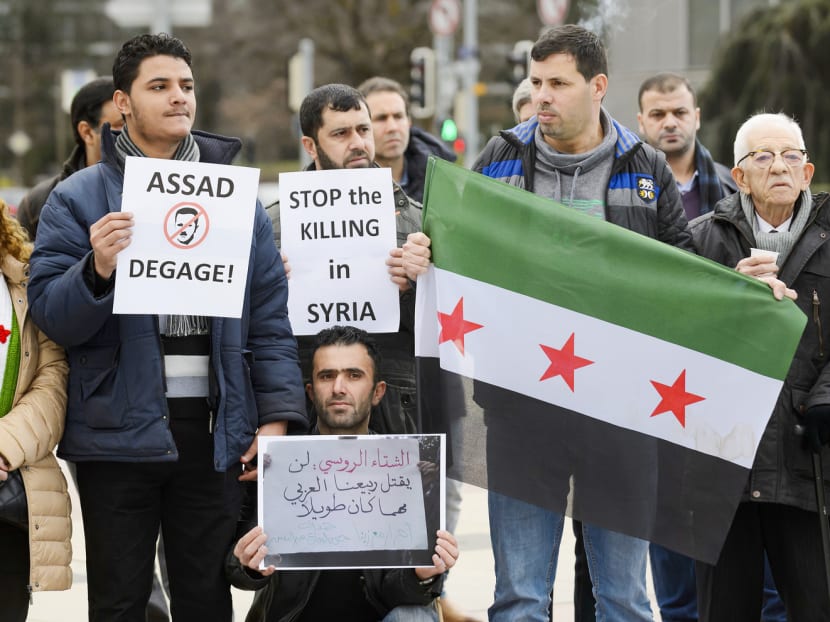 Demonstrators hold up placards and a Free Syria flag in a protest outside the United Nations offices in Geneva on the opening day of the Syrian peace talks. The absence of key opposition members threatens to derail the biggest diplomatic push yet to resolve the country’s civil war. Photo: AFP