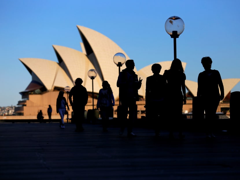 People walk in front of the Sydney Opera House. photo: Reuters