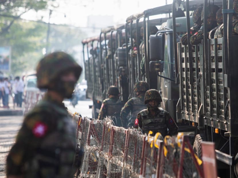 Soldiers standing next to military vehicles as people gathered to protest against a military coup in Yangon, Myanmar on Feb 15, 2021. 