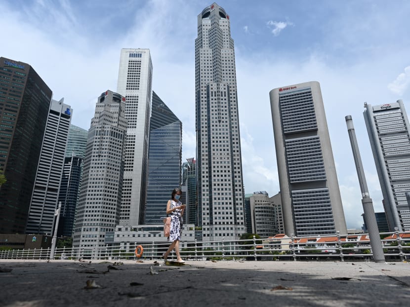 A woman walks past commercial buildings in the financial business district in Singapore on June 11, 2020.