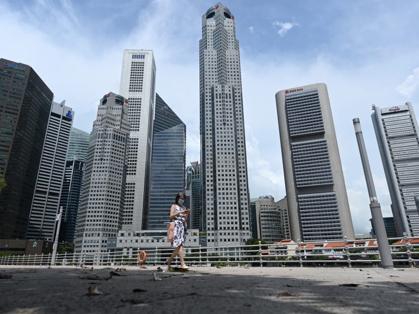 A woman walks past commercial buildings in the financial business district in Singapore on June 11, 2020. A woman walks past commercial buildings in the financial business district in Singapore on June 11, 2020.